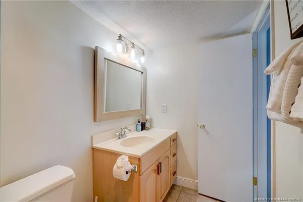 a bathroom with a sink vanity granite and toilet