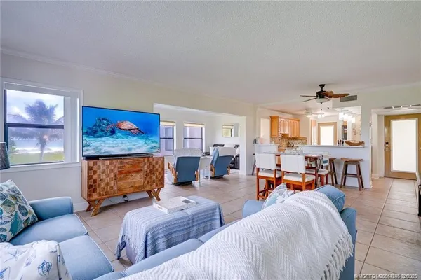 a living room with furniture kitchen view and a window