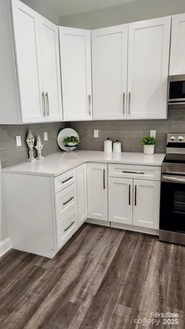 a kitchen with stainless steel appliances granite countertop a sink a stove and cabinets