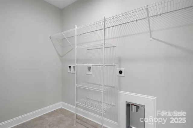 a bed sitting in a spacious bedroom next to a window