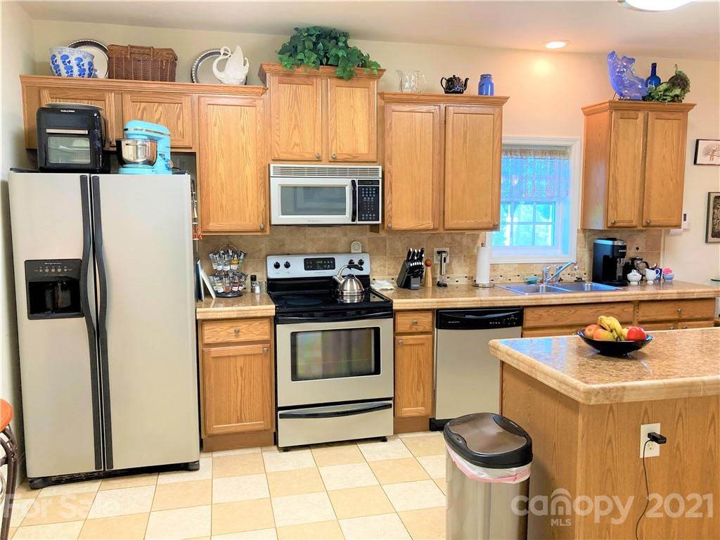 1821 Cove Road Rutherfordton, NC 28139 - Photo 14 of 46 a kitchen with stainless steel appliances a stove a sink cabinets and a refrigerator