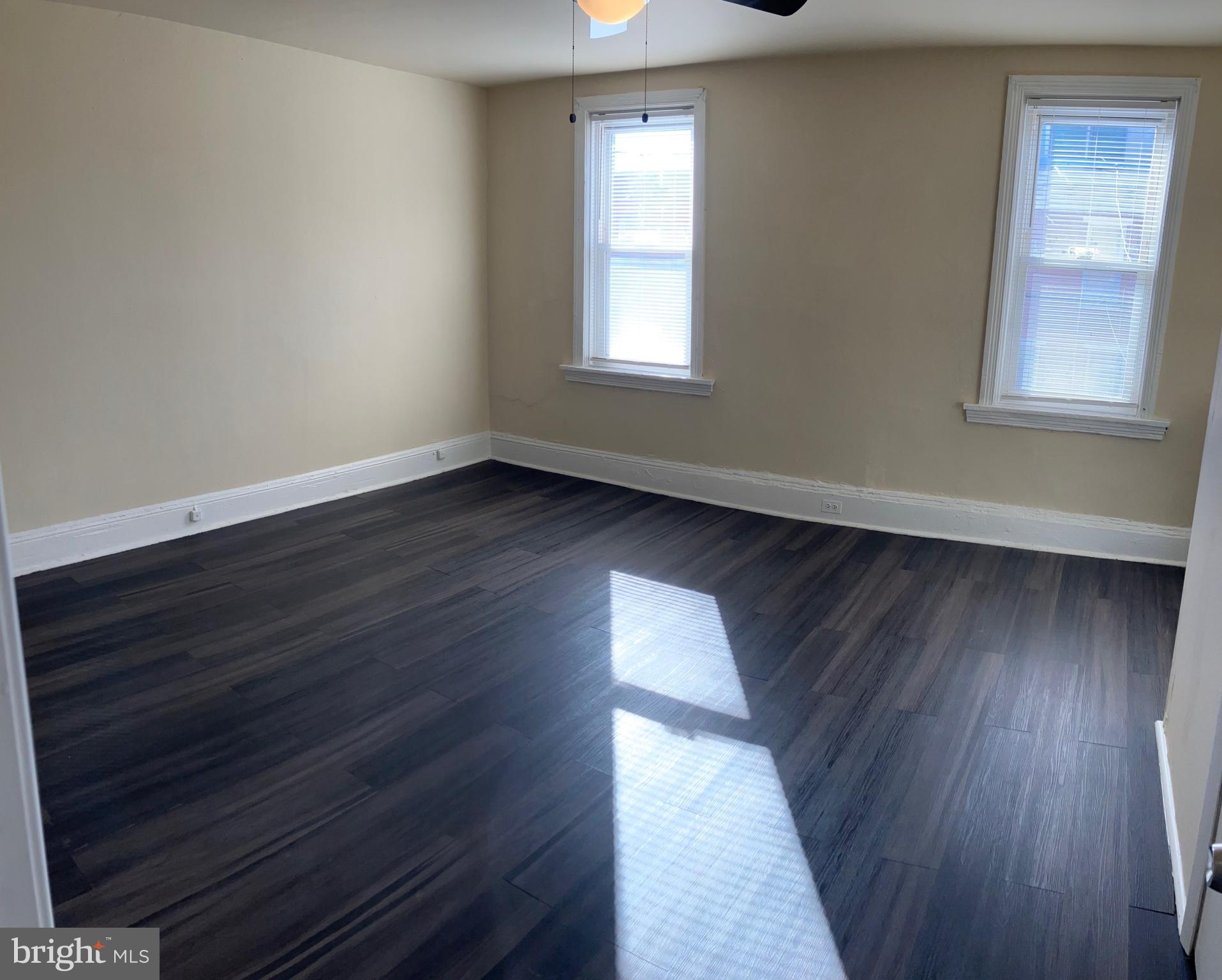 2215 Catharine Street, Unit 2 Philadelphia, PA 19146 - Photo 2 of 11 a view of an empty room with wooden floor and a window