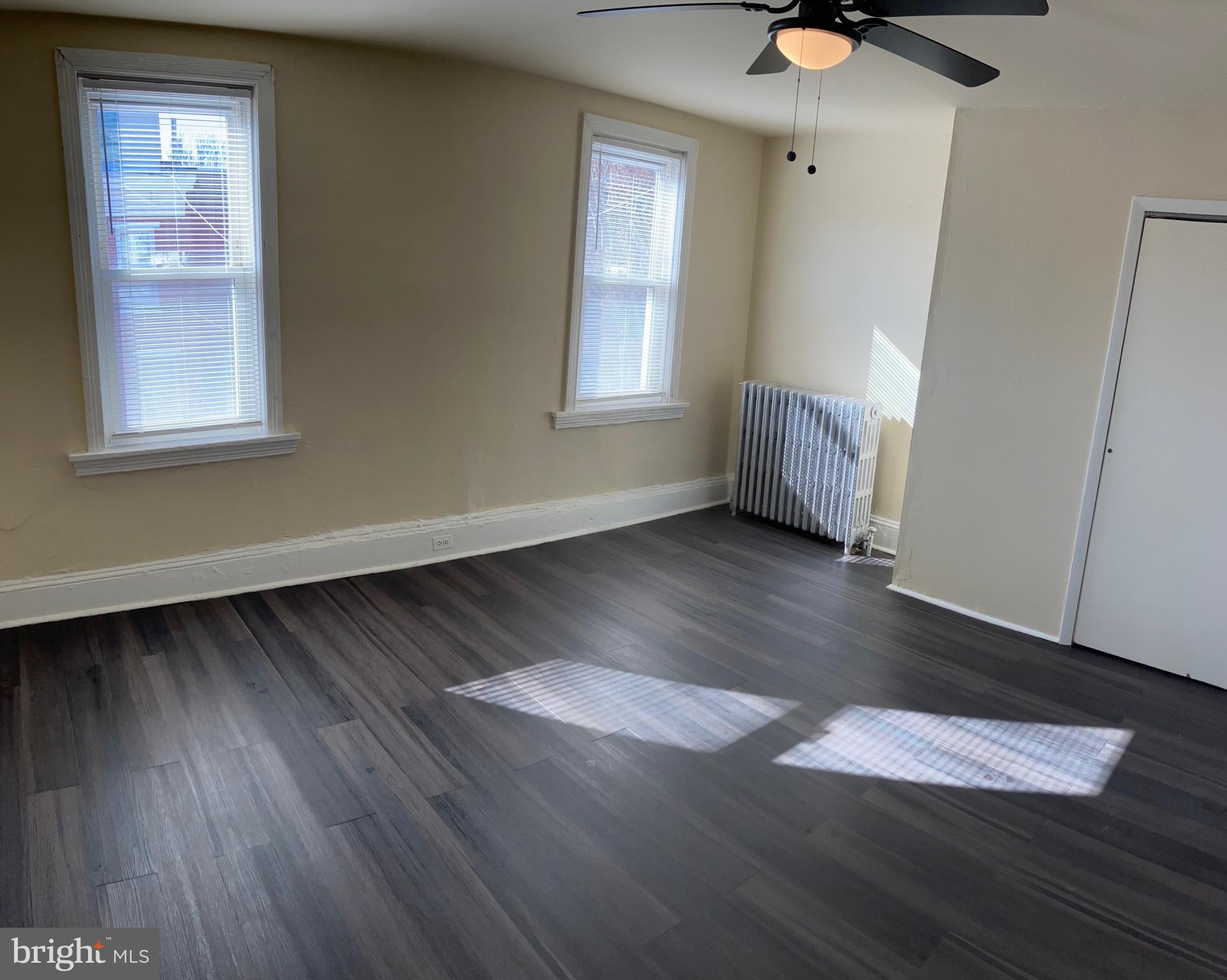 2215 Catharine Street, Unit 2 Philadelphia, PA 19146 - Photo 4 of 11 a view of an empty room with wooden floor and a window