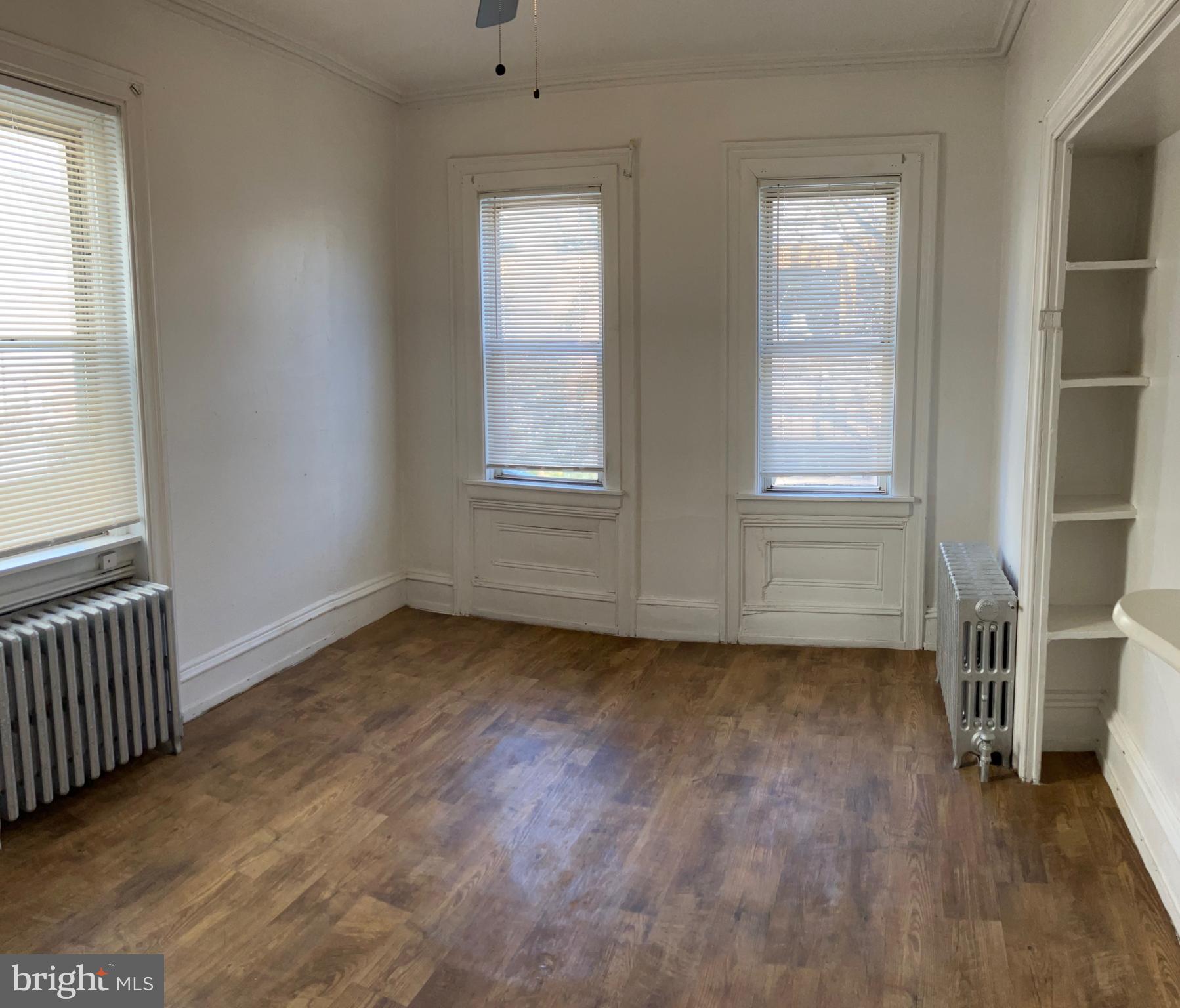 2215 Catharine Street, Unit 2 Philadelphia, PA 19146 - Photo 5 of 11 an empty room with wooden floor and windows
