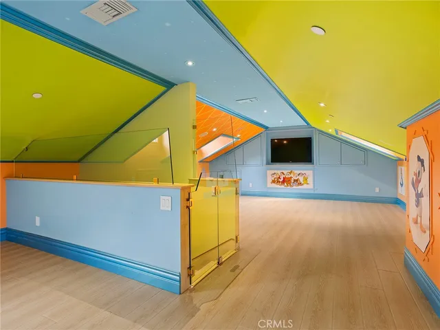 a bedroom with a bed and a lamp on the dresser