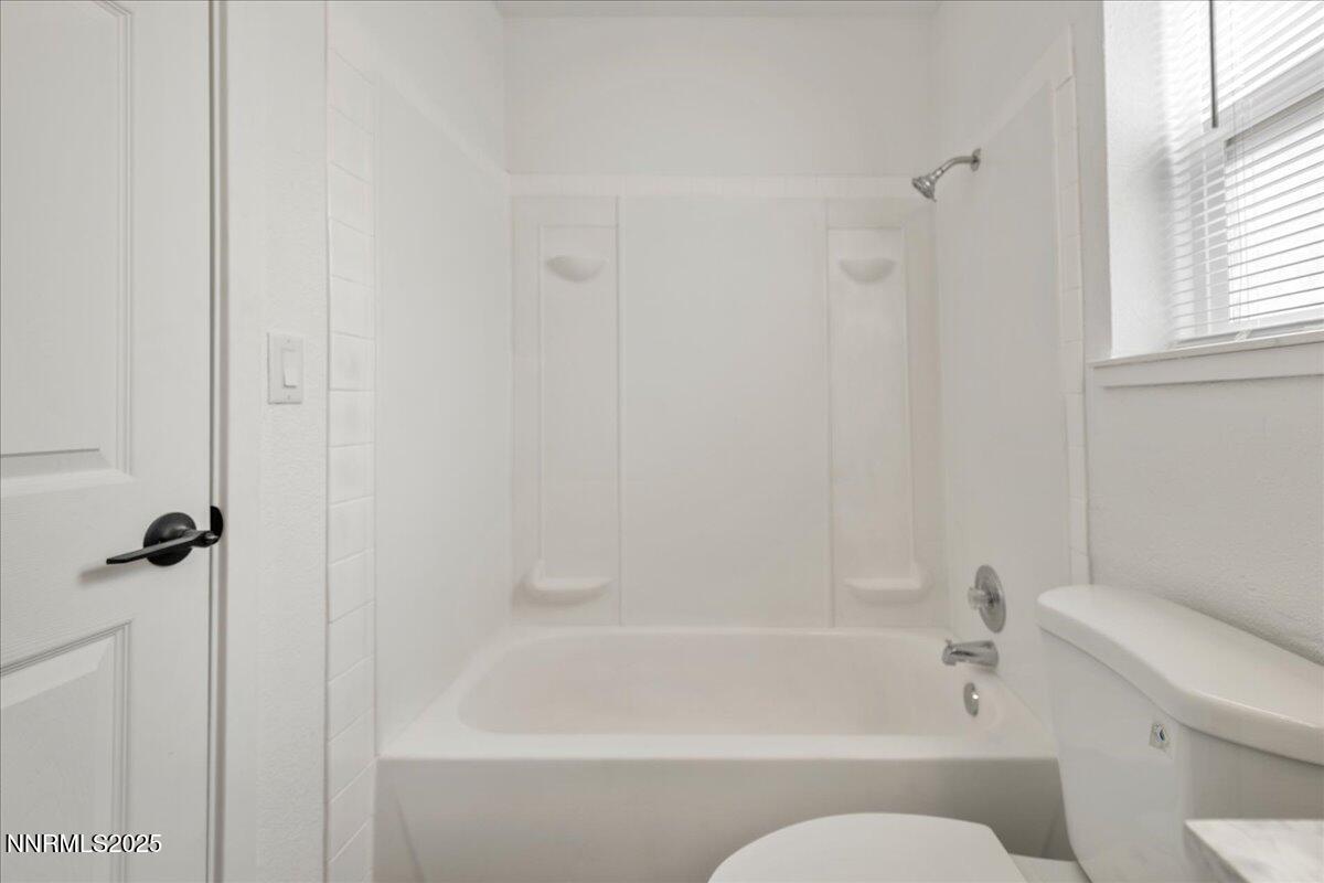 10038 Humite Lane Reno, NV 89506 - Photo 23 of 30 a bathroom with a bathtub and a toilet