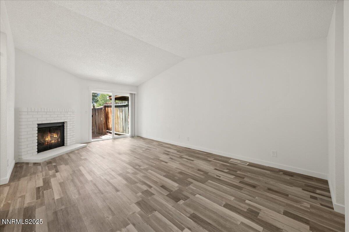 10038 Humite Lane Reno, NV 89506 - Photo 6 of 30 a view of empty room with wooden floor and fireplace