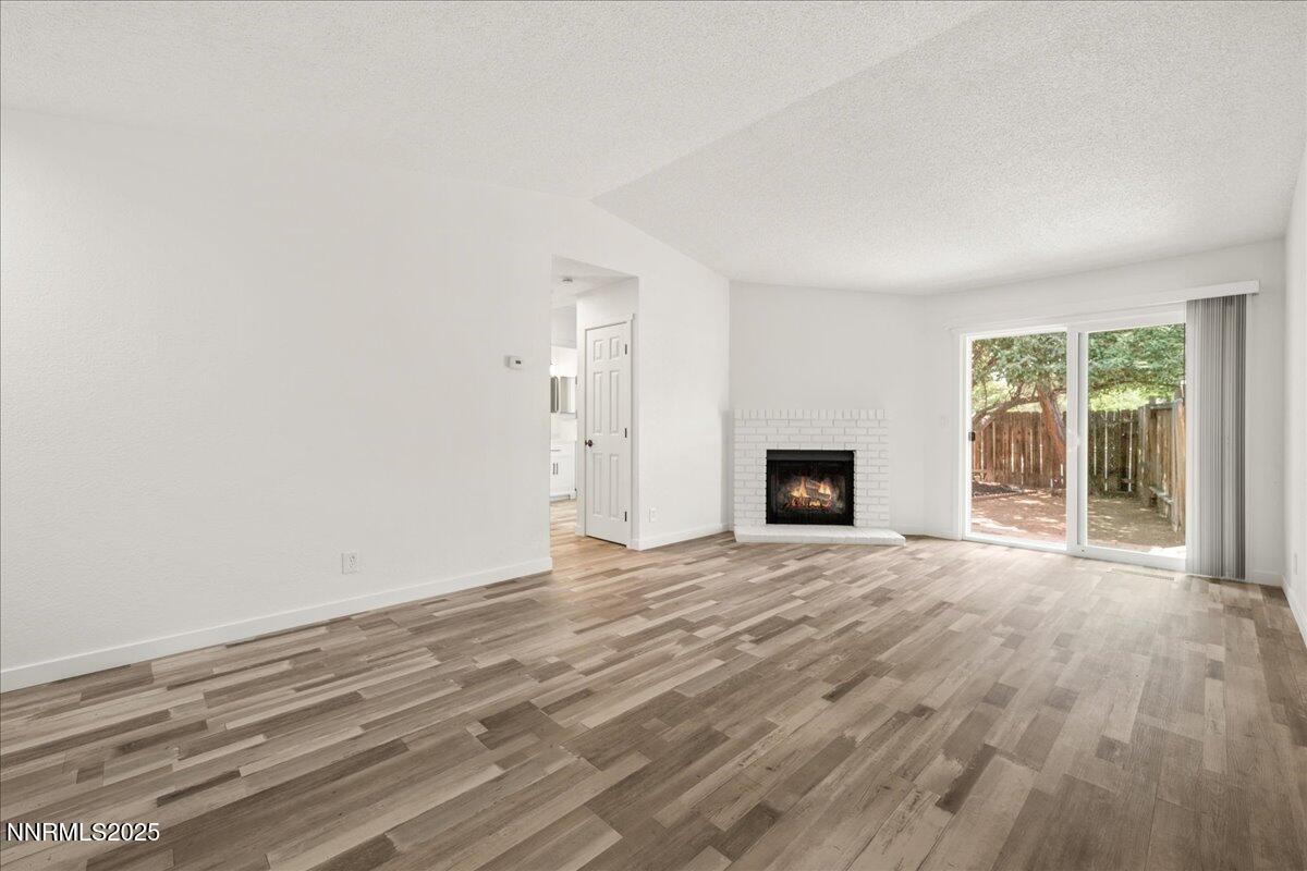 10038 Humite Lane Reno, NV 89506 - Photo 8 of 30 a view of empty room with wooden floor and fireplace