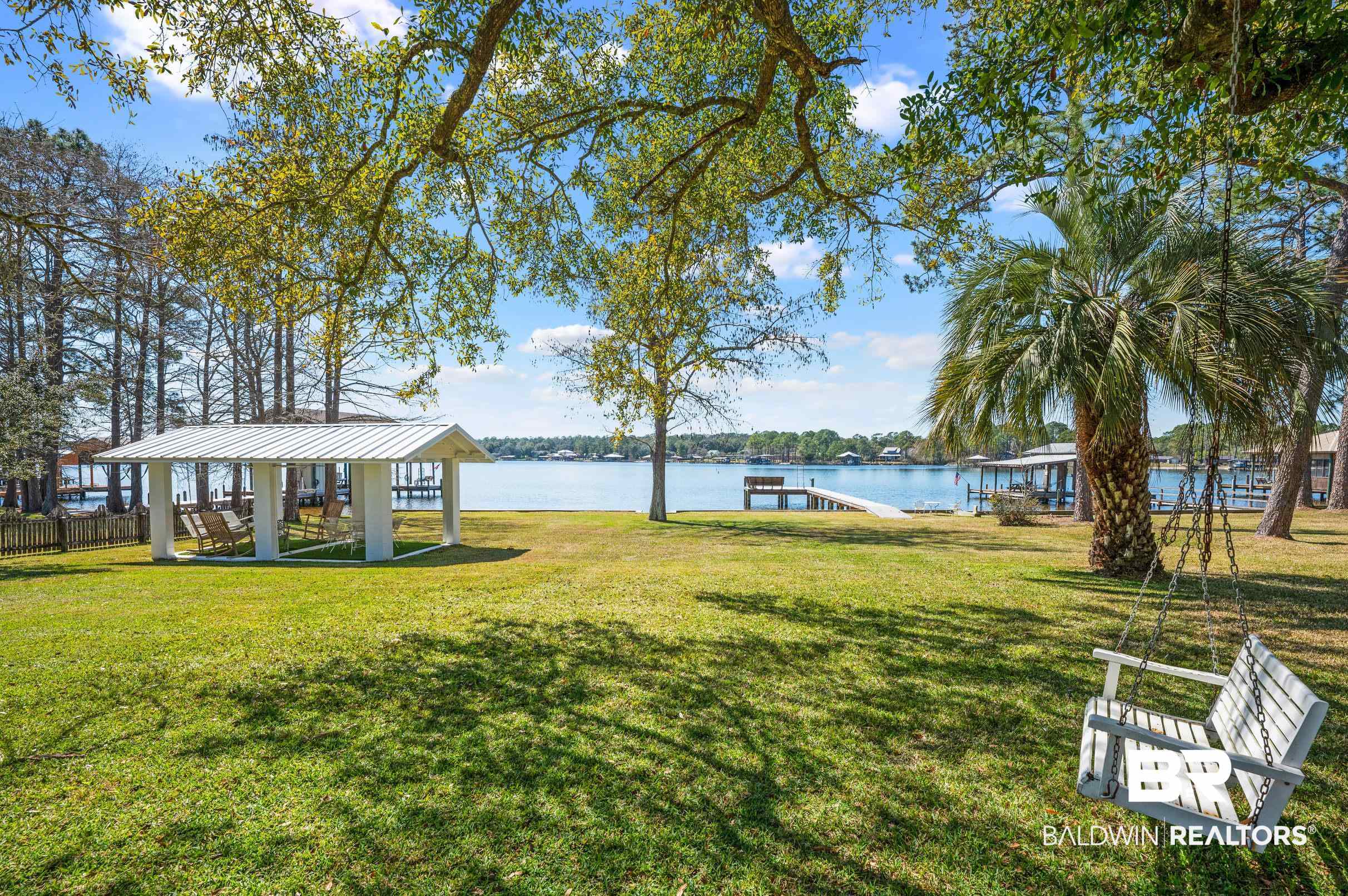 9459 Soldier Creek Road Lillian, AL 36549 - Photo 29 of 54 View of yard with a water view, a boat dock, a gazebo, and fence