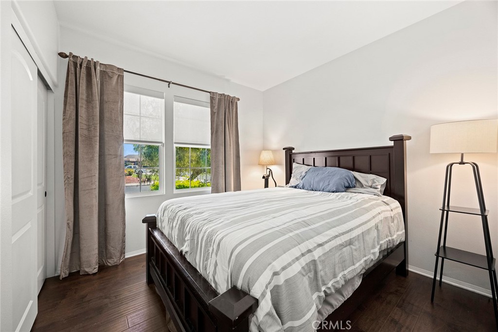 7357 Max Way Eastvale, CA 92880 - Photo 11 of 39 a bedroom with a bed lamp and a large window