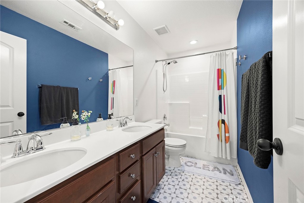 7357 Max Way Eastvale, CA 92880 - Photo 18 of 39 a bathroom with a double vanity sink toilet mirror and shower