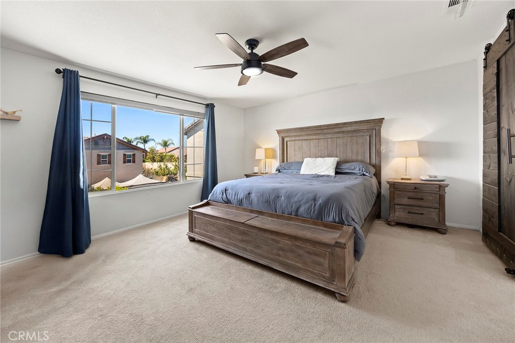 7357 Max Way Eastvale, CA 92880 - Photo 21 of 39 a bedroom with a bed and a large window