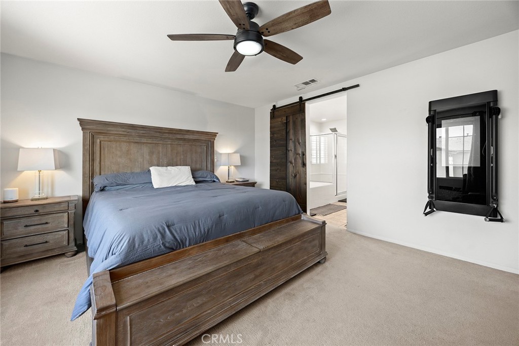 7357 Max Way Eastvale, CA 92880 - Photo 22 of 39 a bedroom with a large bed and a ceiling fan