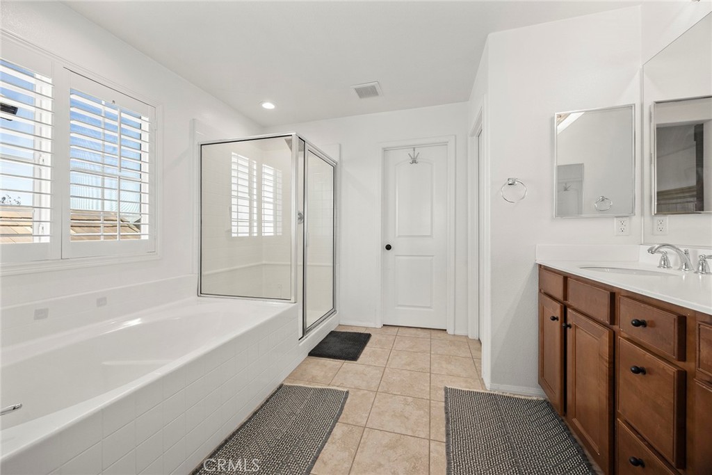 7357 Max Way Eastvale, CA 92880 - Photo 24 of 39 a bathroom with a tub shower and sink