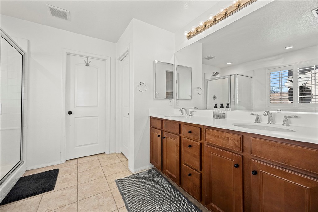 7357 Max Way Eastvale, CA 92880 - Photo 25 of 39 a spacious bathroom with double sink and a mirror