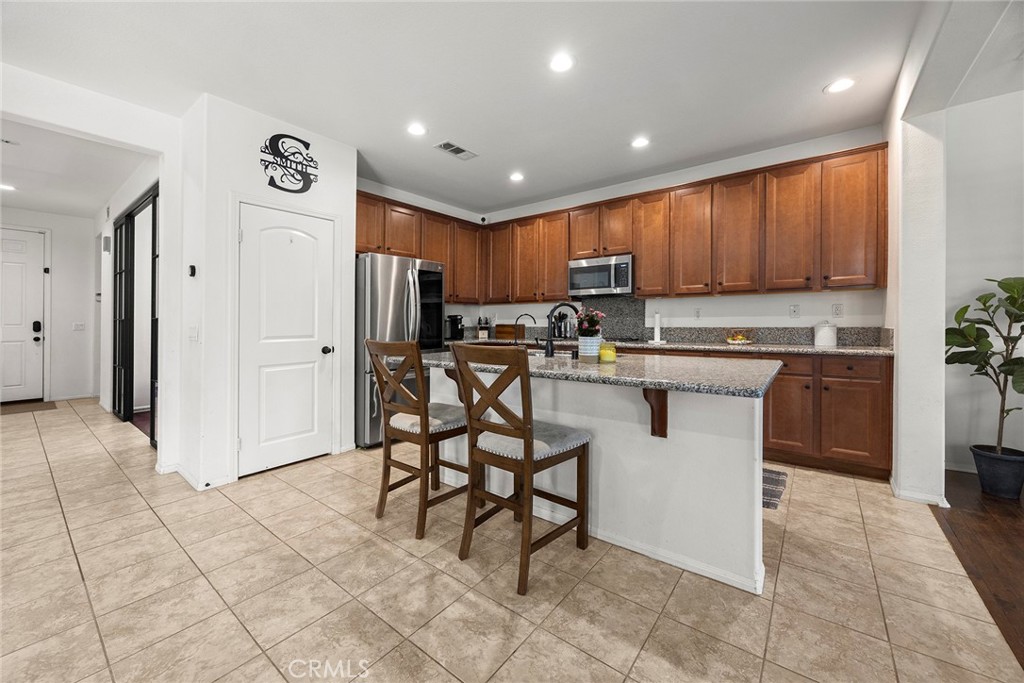 7357 Max Way Eastvale, CA 92880 - Photo 7 of 39 a kitchen with stainless steel appliances granite countertop a stove a sink and a refrigerator