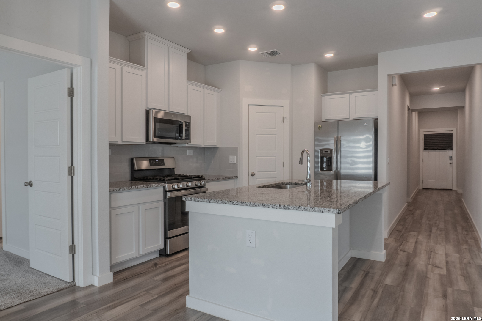 175 Ryan Crossing San Antonio, TX 78253 - Photo 8 of 37 a kitchen with stainless steel appliances granite countertop a refrigerator a stove and a wooden floors