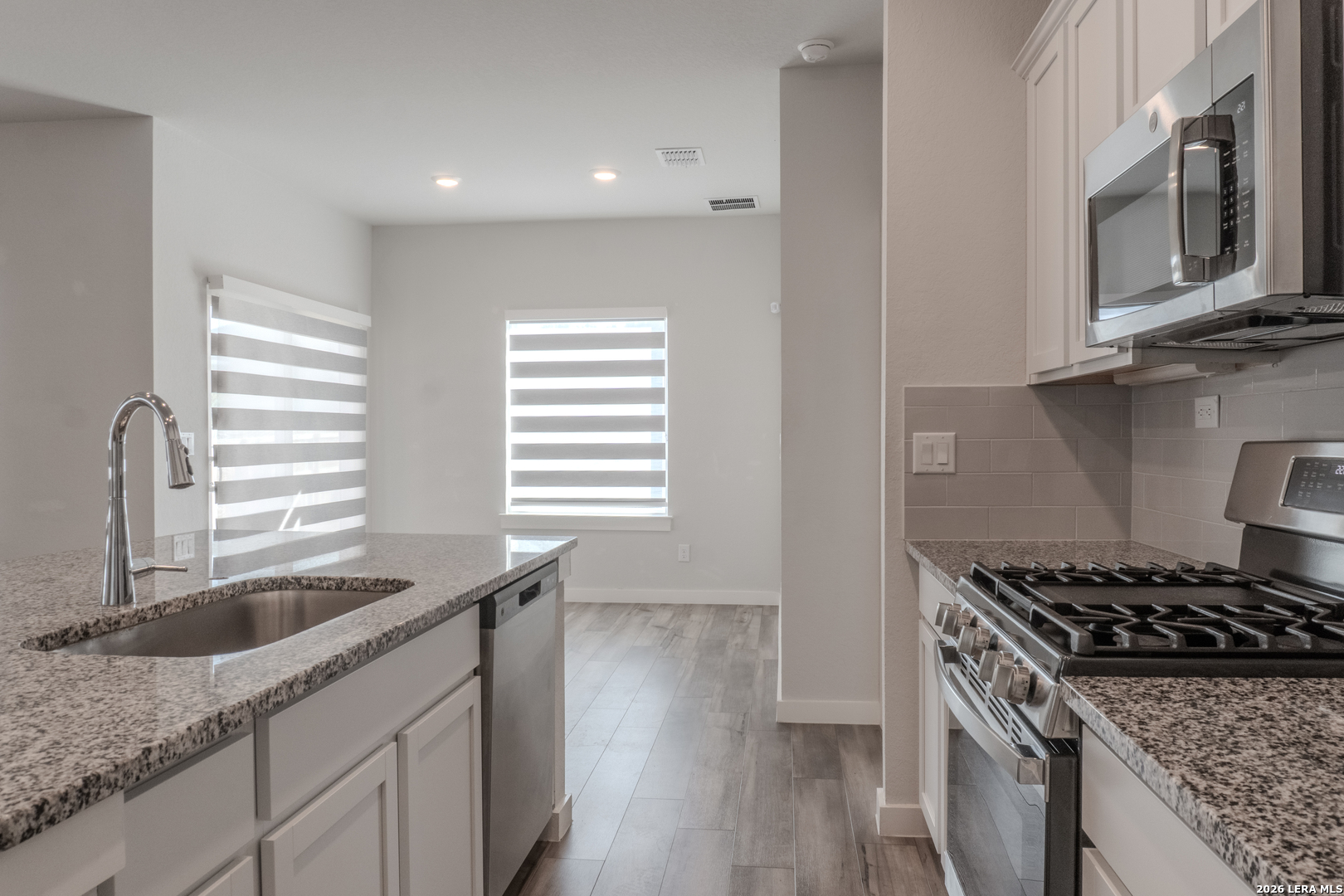 175 Ryan Crossing San Antonio, TX 78253 - Photo 9 of 37 a kitchen with granite countertop a sink stove and cabinets