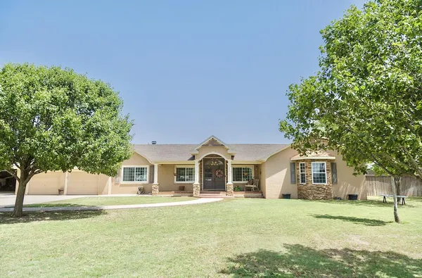 a front view of a house with a garden and yard