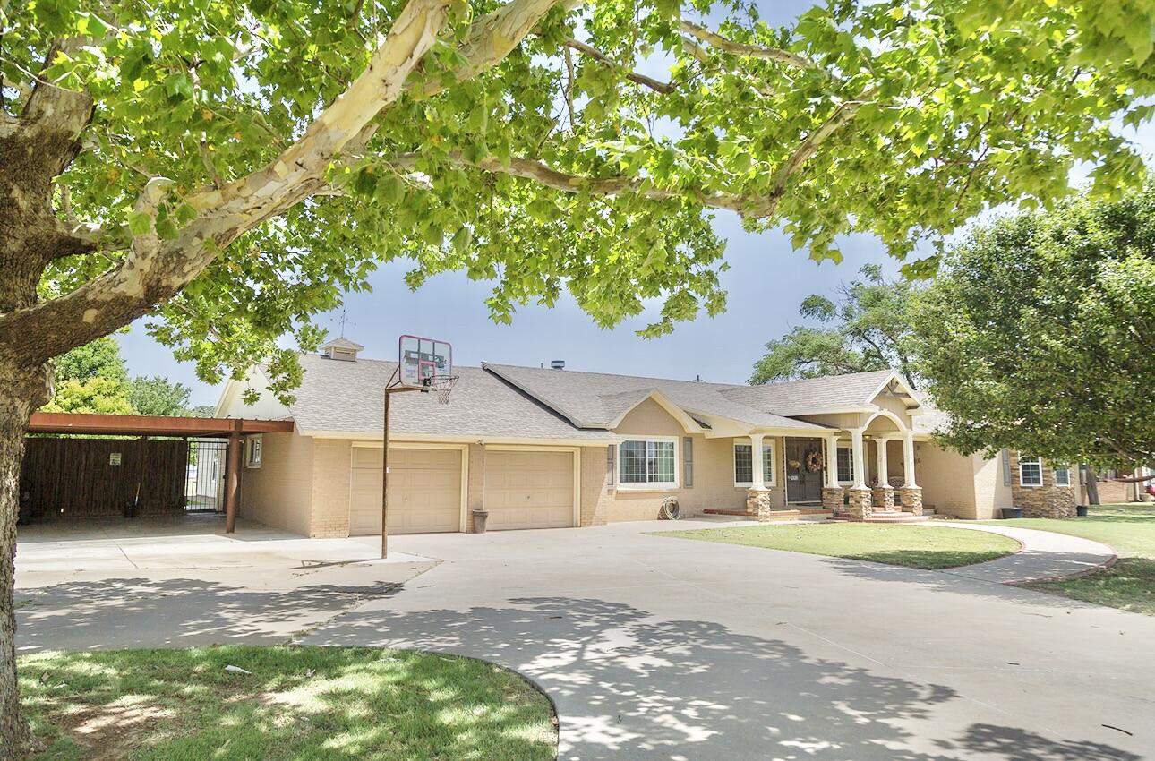 1308 West 24th Street Plainview, TX 79072 - Photo 2 of 85 a front view of a house with a garden and trees
