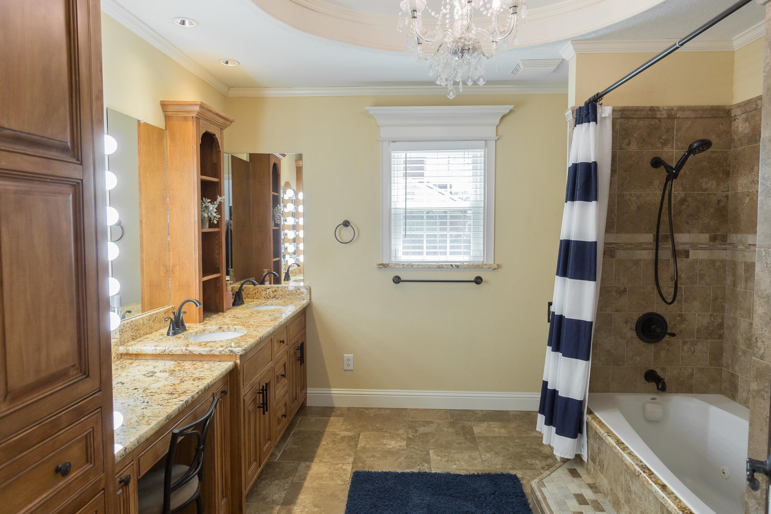 1308 West 24th Street Plainview, TX 79072 - Photo 60 of 85 a bathroom with a granite countertop sink a mirror a bathtub and shower