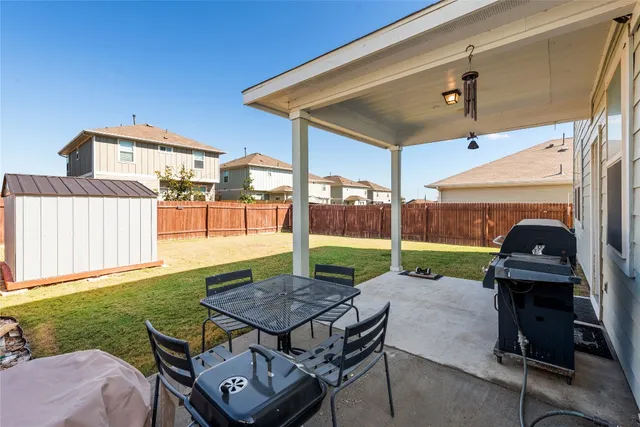 a view of a porch with couches chairs and wooden fence
