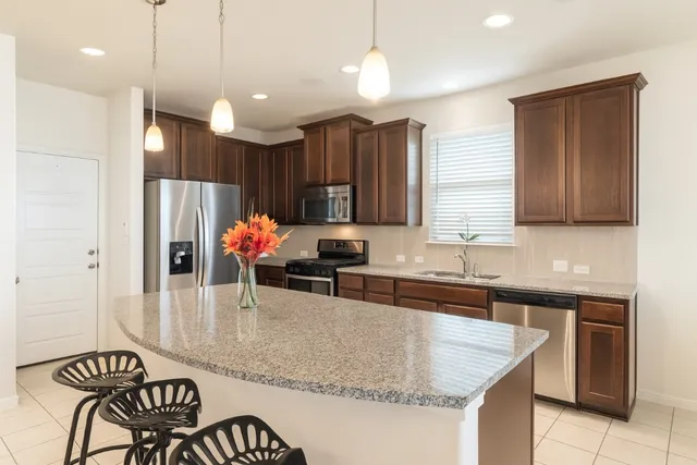 a large kitchen with kitchen island a table and chairs