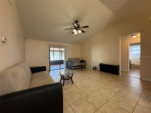 a living room with furniture and a ceiling fan