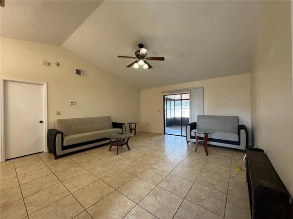 a living room with furniture and a ceiling fan