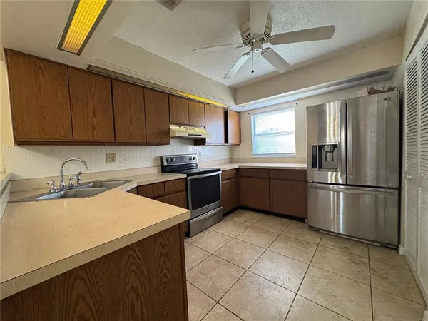 a kitchen with stainless steel appliances granite countertop a sink a stove a refrigerator a microwave with cabinets and a refrigerator