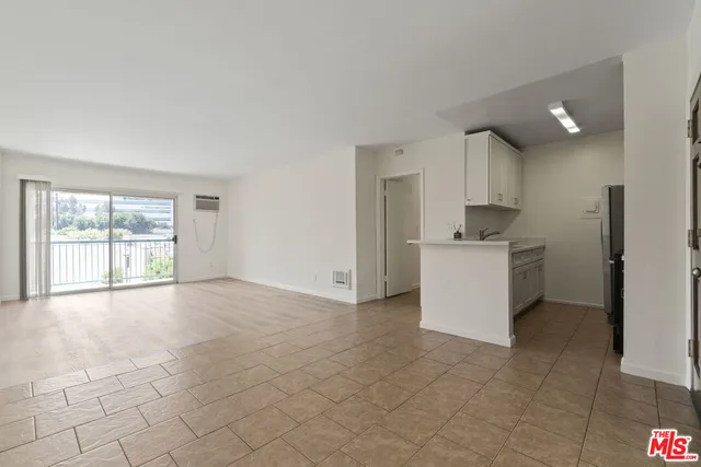 a view of a kitchen with a sink and dishwasher a refrigerator with white cabinets