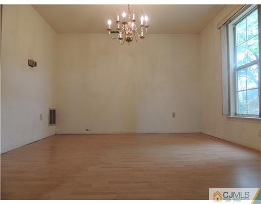 2304 Buckingham Circle Middletown, NJ 07748 - Photo 11 of 25 en empty room with windows and chandelier fan