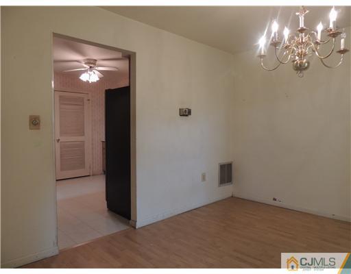 2304 Buckingham Circle Middletown, NJ 07748 - Photo 12 of 25 en empty room with chandelier fan