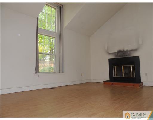 2304 Buckingham Circle Middletown, NJ 07748 - Photo 5 of 25 an empty room with floor to ceiling windows and fireplace