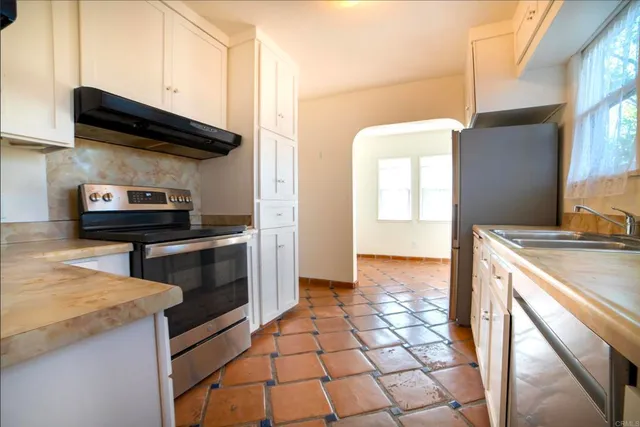 a kitchen with a sink a stove and cabinets