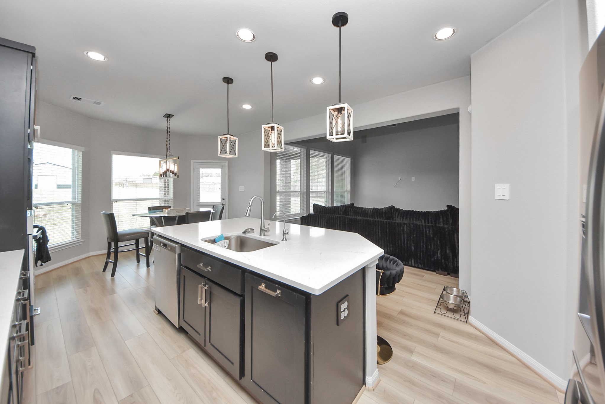 16735 Rockwall Street Conroe, TX 77303 - Photo 10 of 37 The kitchen flows seamlessly into the expansive living room, creating a bright and welcoming gathering space filled with natural light and beautiful views of the backyard and surrounding property.