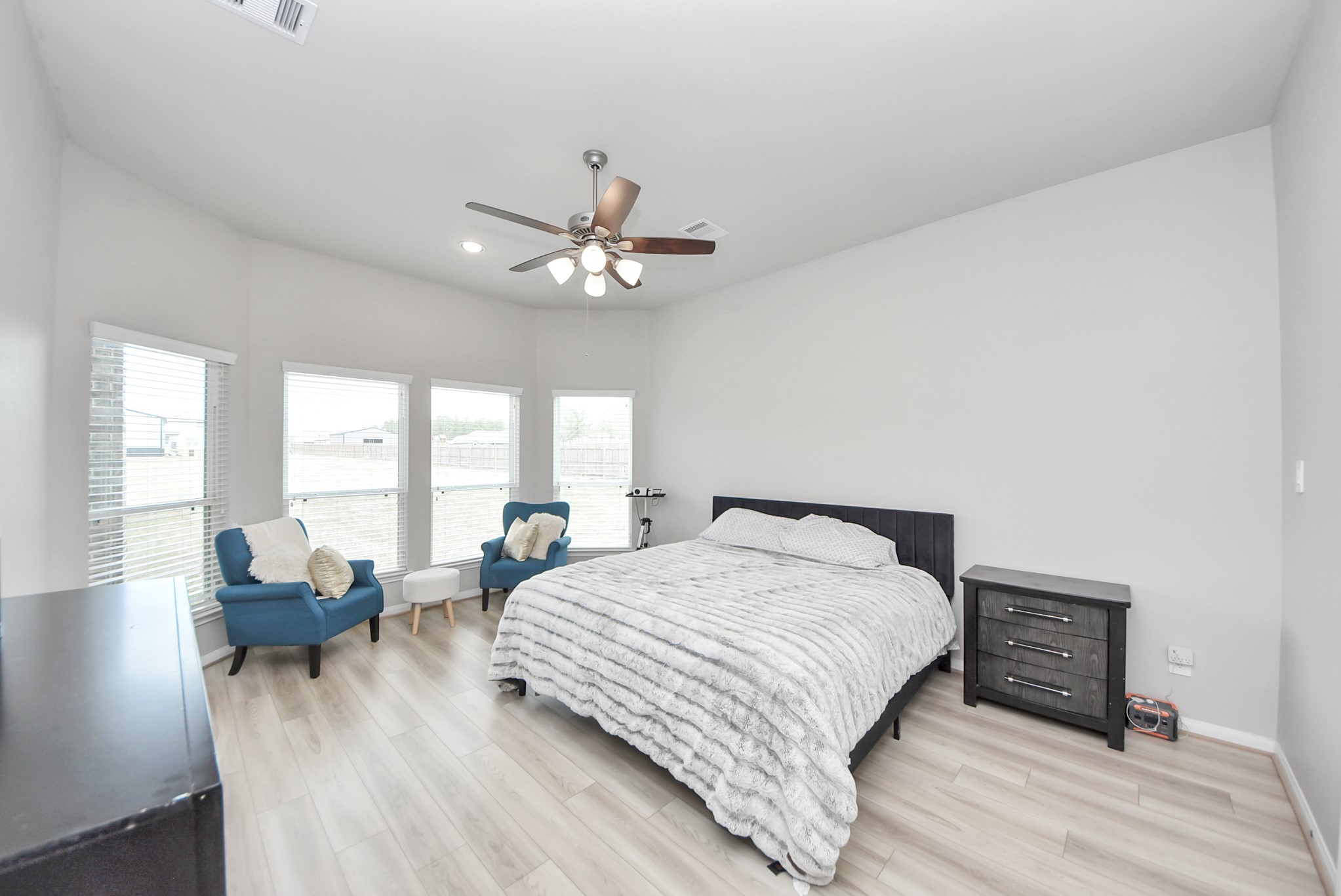 16735 Rockwall Street Conroe, TX 77303 - Photo 17 of 37 a spacious bedroom with a bed a couch and large windows
