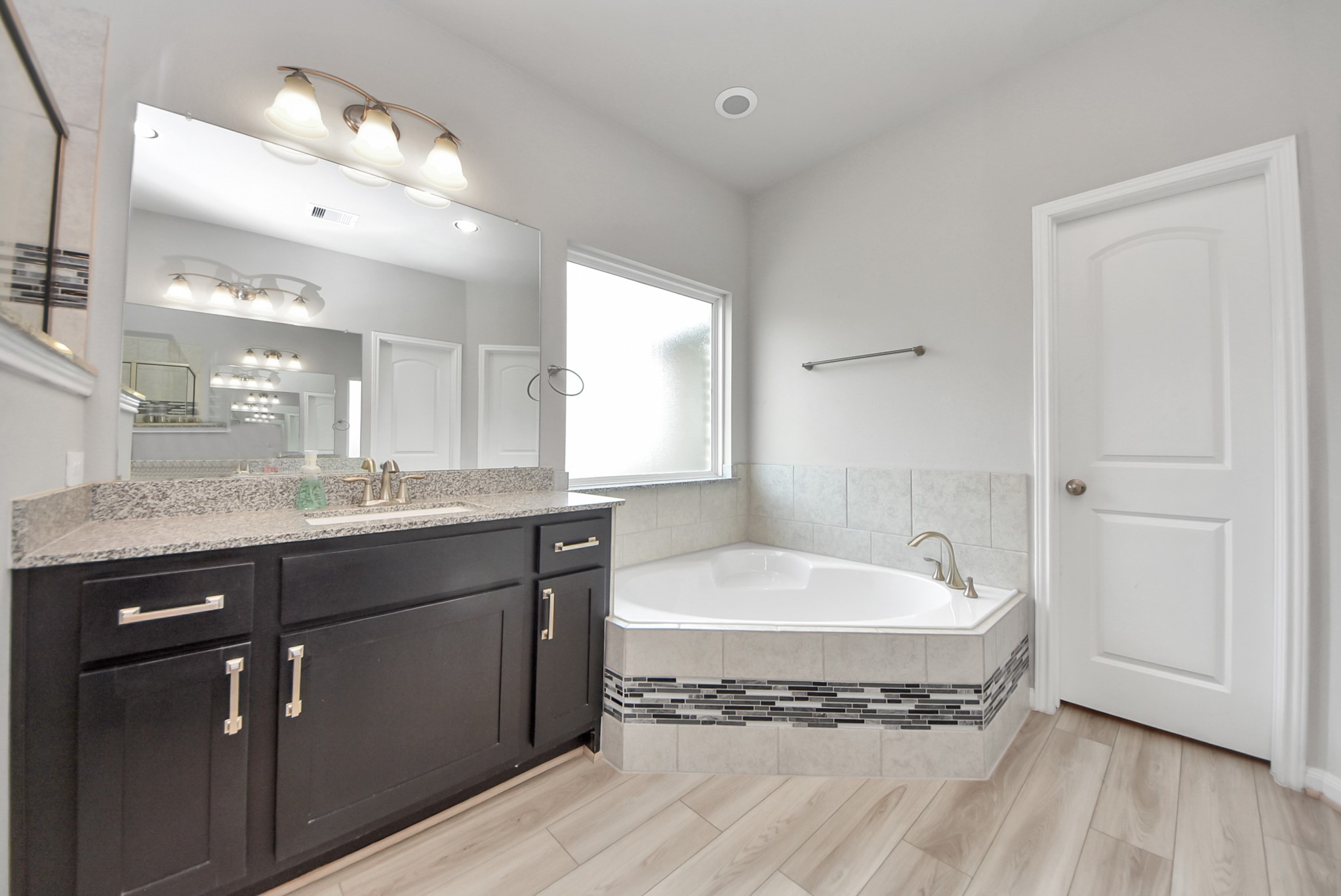 16735 Rockwall Street Conroe, TX 77303 - Photo 18 of 37 a spacious bathroom with a granite countertop sink a mirror and bathtub