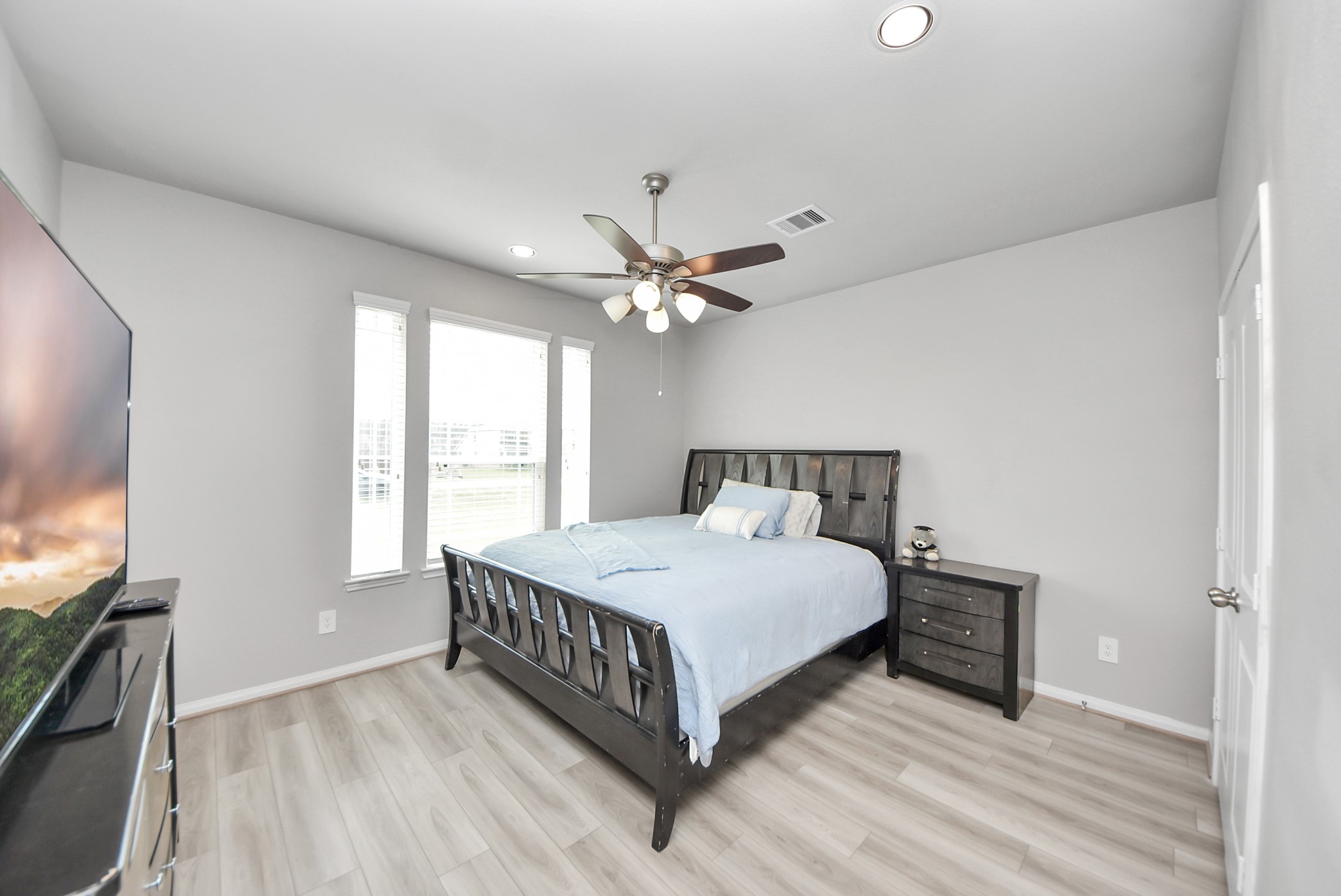 16735 Rockwall Street Conroe, TX 77303 - Photo 20 of 37 a bedroom with a large bed chandelier and a window