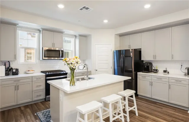 a kitchen with a sink refrigerator and a stove