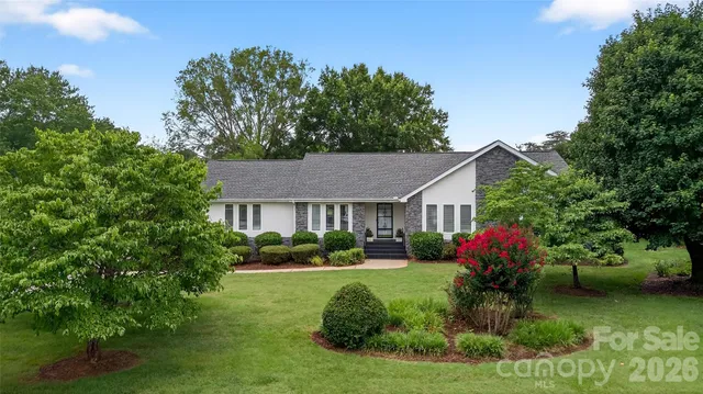a front view of a house with a yard and potted plants