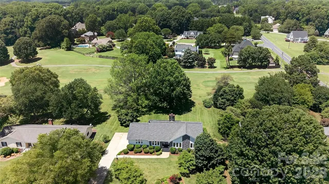 an aerial view of a house with a yard and lake view