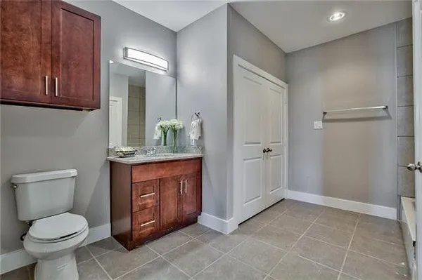 a bathroom with a granite countertop toilet and a sink