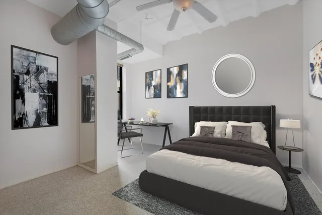 a bedroom with a large bed and a chandelier