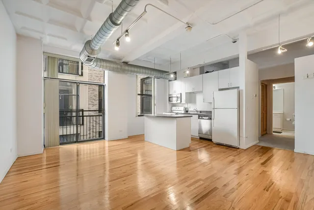 a view of kitchen with stainless steel appliances refrigerator oven and cabinets