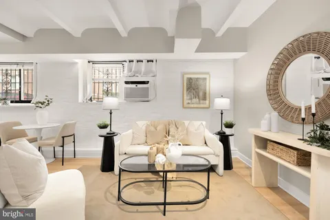 a living room with furniture a flat screen tv and a table