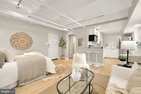 a living room with furniture a flat screen tv and kitchen view