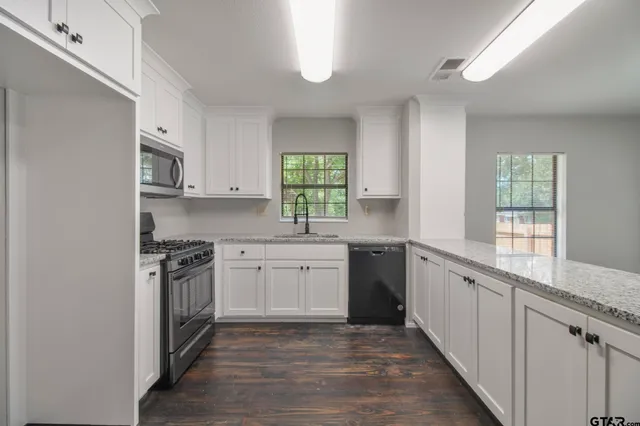 a kitchen with stainless steel appliances granite countertop a stove a sink and a refrigerator
