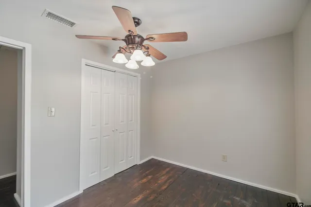 an empty room with a chandelier fan