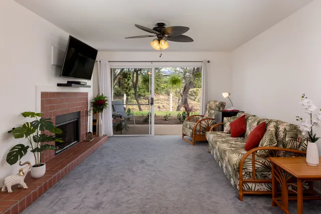 a living room with furniture a fireplace and a flat screen tv